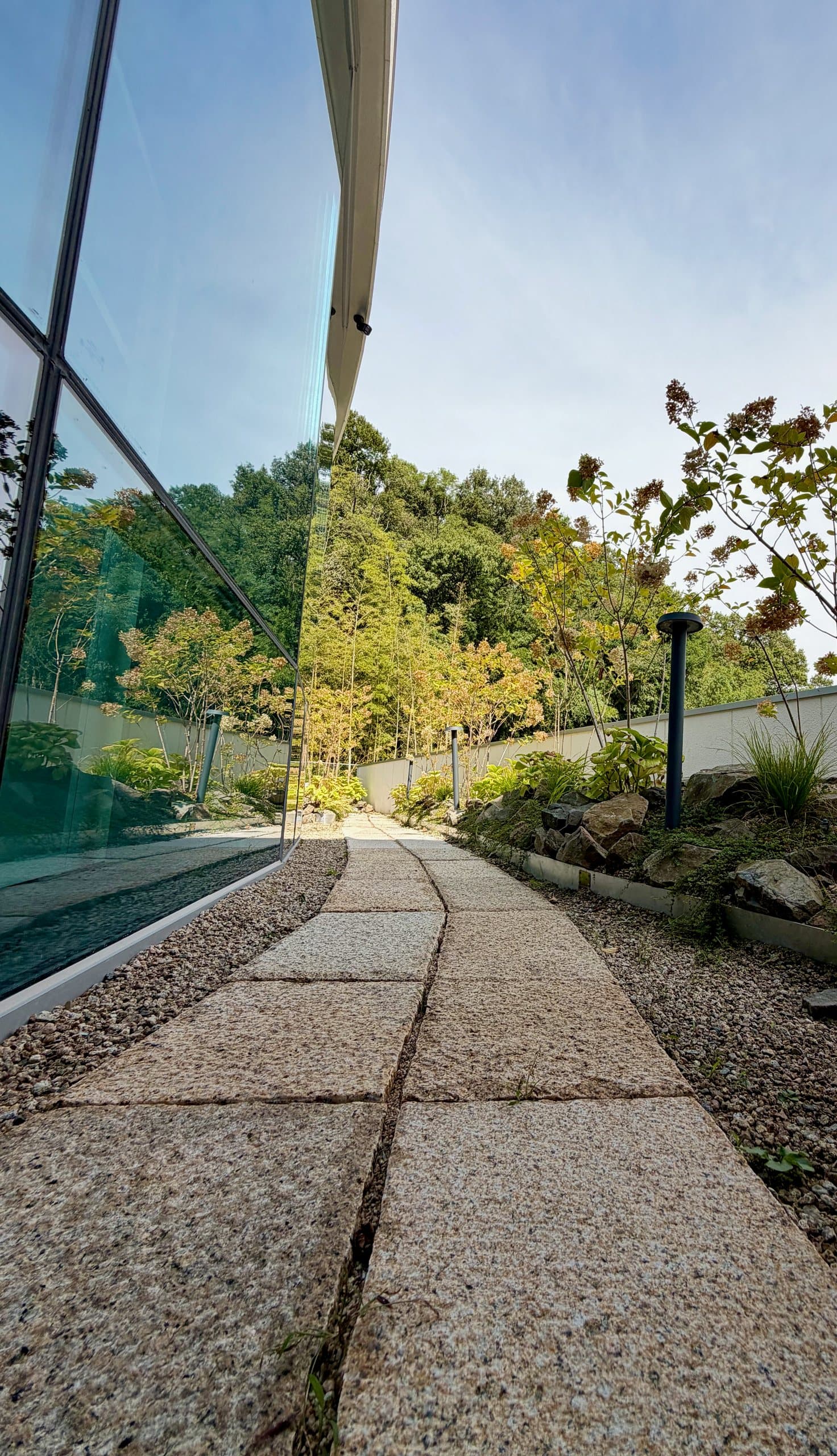 A granite stone path along the glass wall