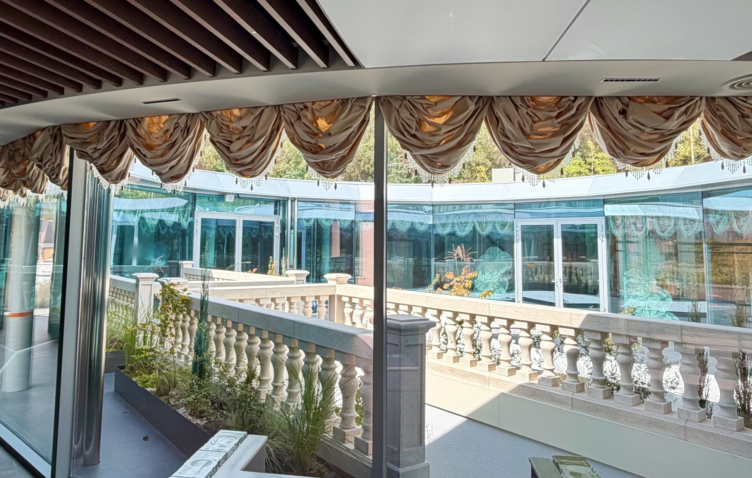 From the hall, a view through draped windows onto the terrace